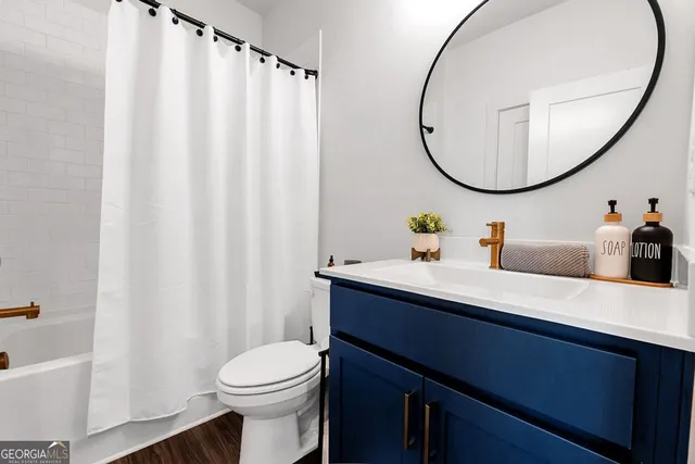 a bathroom with a sink a mirror a toilet and a bathtub