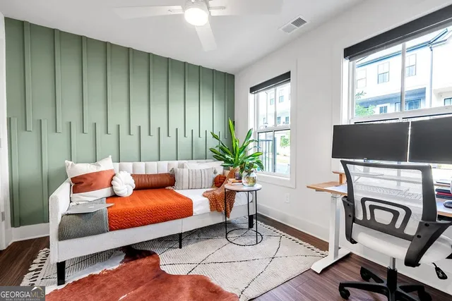 a living room with furniture a flat screen tv and a window