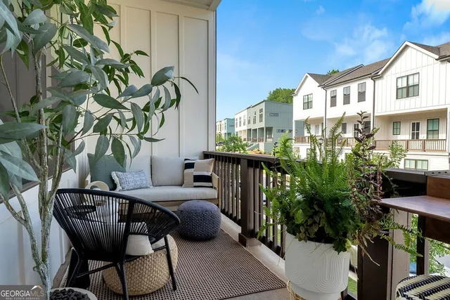 a view of a balcony with chairs and a potted plant