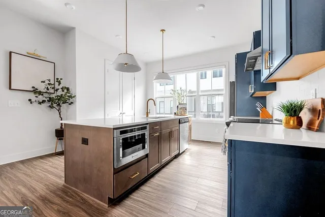 a kitchen with stainless steel appliances a white stove top oven and a wooden floor
