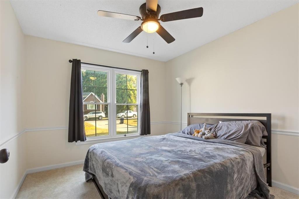 58 Quail Run Cartersville, GA 30120 - Photo 24 of 44 a bedroom with a large bed and a chandelier