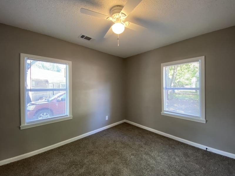 2119 Pendleton Street Memphis, TN 38114 - Photo 6 of 8 a view of an empty room with window and chandelier fan