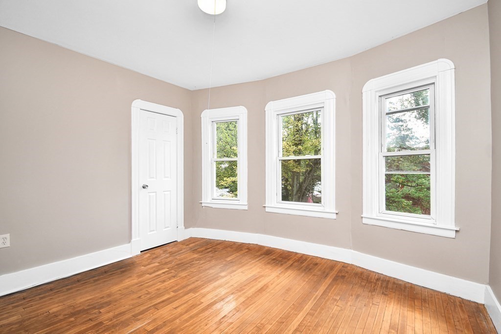 335 Oakland Street Springfield, MA 01108 - Photo 19 of 42 an empty room with wooden floor and windows