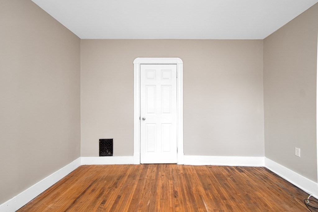 335 Oakland Street Springfield, MA 01108 - Photo 22 of 42 a view of an empty room with wooden floor and a window