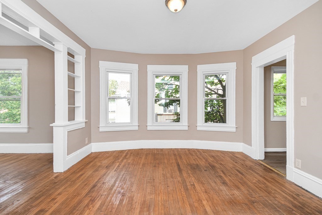 335 Oakland Street Springfield, MA 01108 - Photo 23 of 42 a view of an empty room with wooden floor and a window