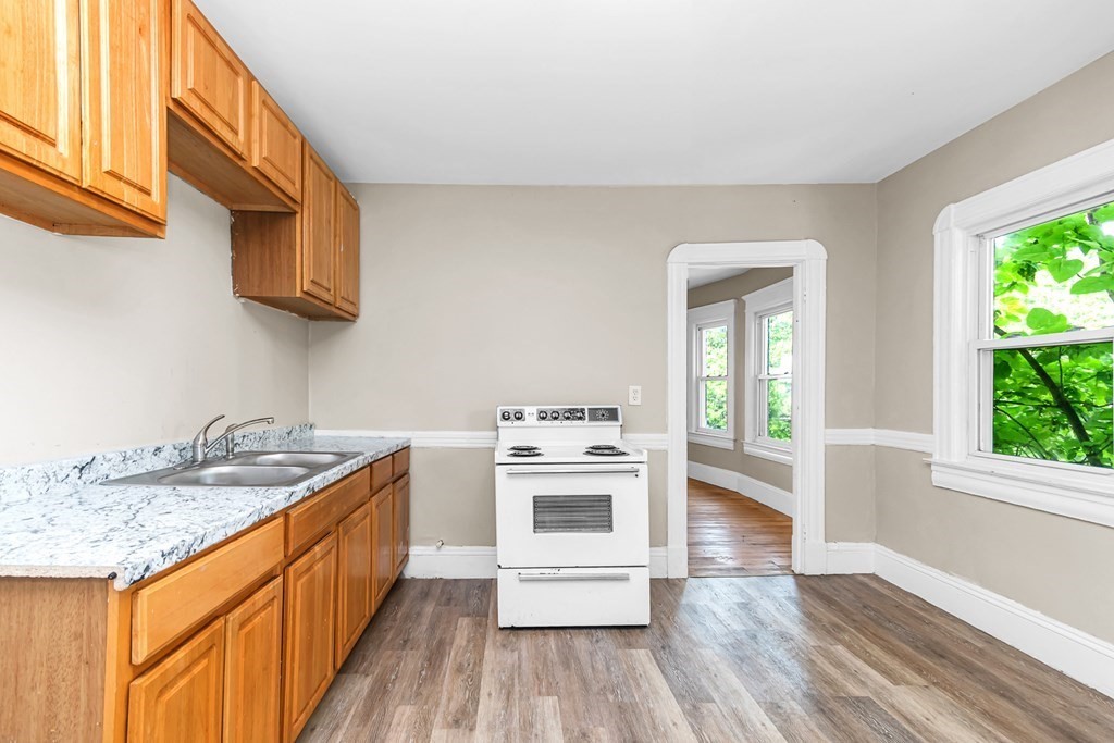 335 Oakland Street Springfield, MA 01108 - Photo 27 of 42 a kitchen with a stove a sink and a microwave