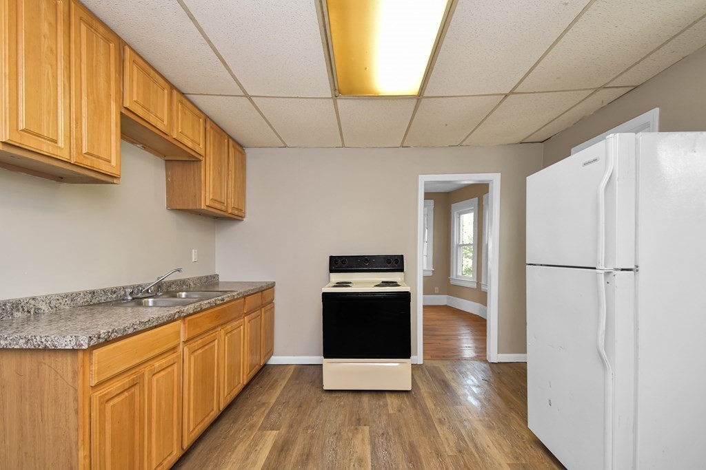 335 Oakland Street Springfield, MA 01108 - Photo 3 of 42 a kitchen with stainless steel appliances granite countertop a refrigerator a stove and a wooden floors