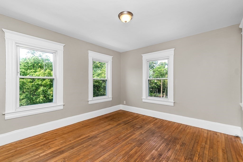 335 Oakland Street Springfield, MA 01108 - Photo 32 of 42 a view of an empty room with wooden floor and a window