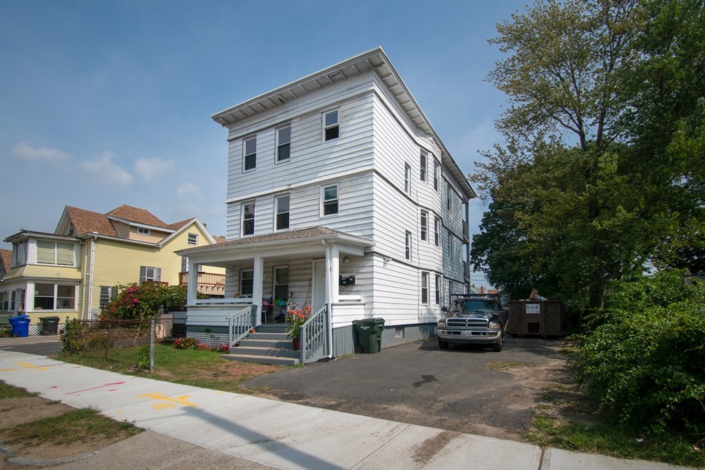 335 Oakland Street Springfield, MA 01108 - Photo 42 of 42 a view of a white house with large windows and a table and chairs