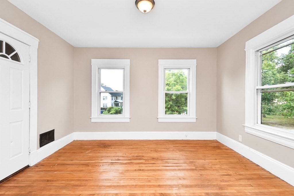 335 Oakland Street Springfield, MA 01108 - Photo 6 of 42 a view of an empty room with wooden floor and window