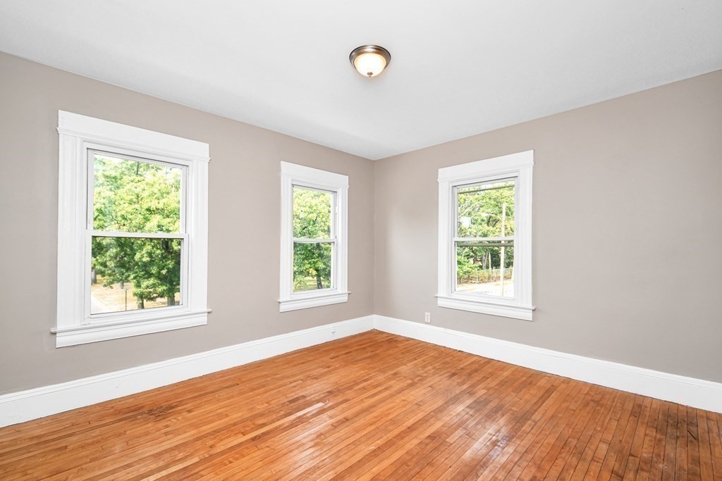 335 Oakland Street Springfield, MA 01108 - Photo 7 of 42 an empty room with wooden floor and windows
