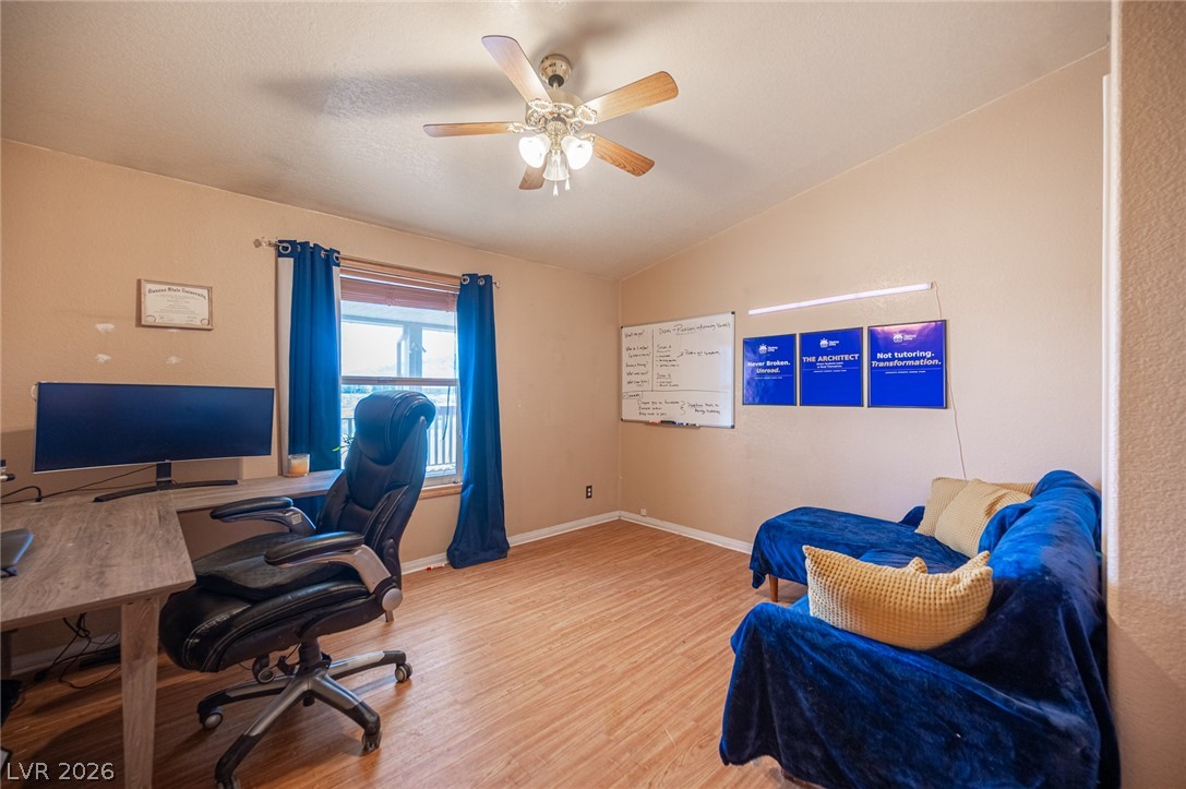 3200 Maple Road Pahrump, NV 89048 - Photo 26 of 53 Well-lit room featuring durable wood flooring and ample space for an office setup or casual seating.