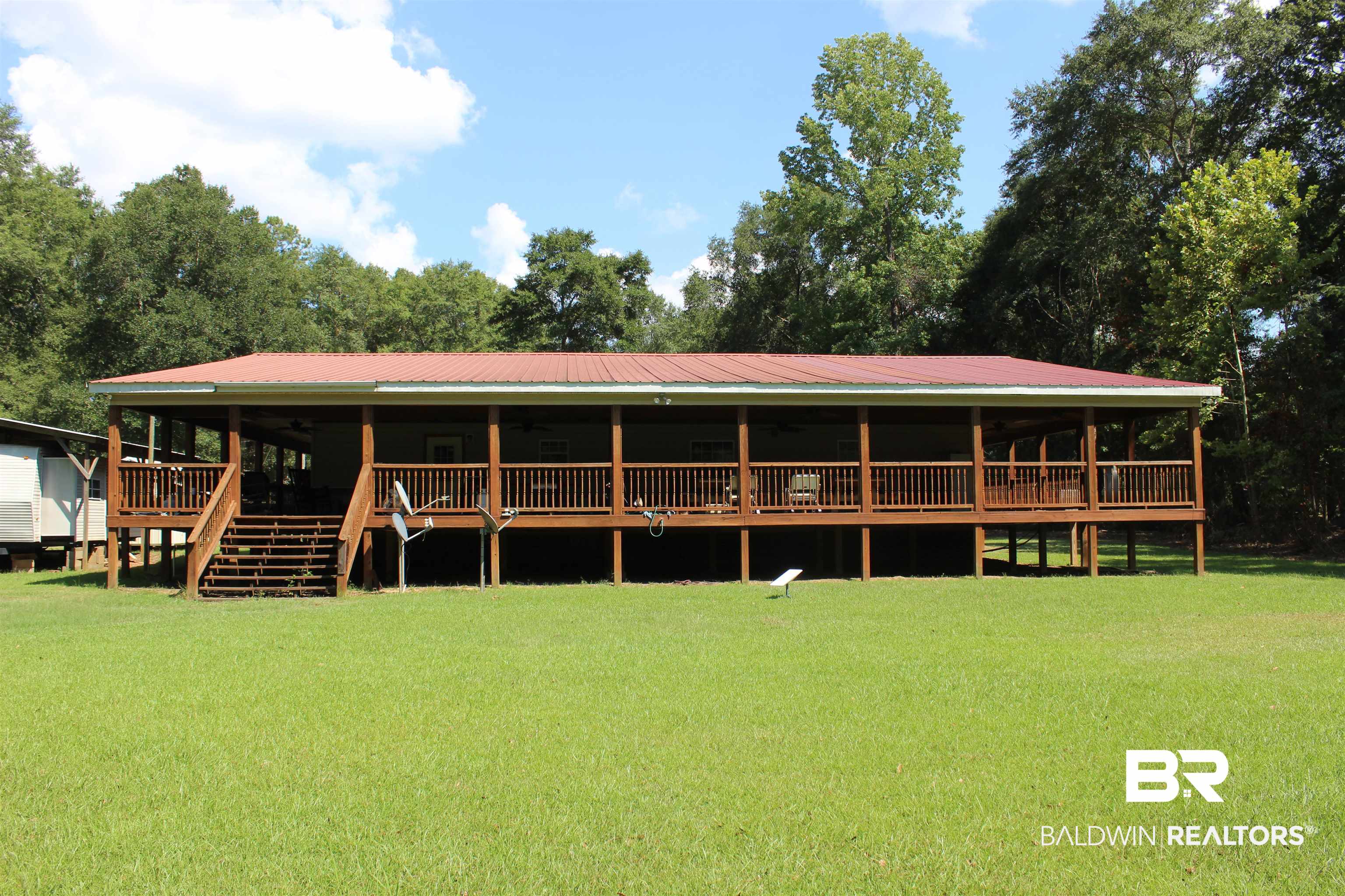 7258 Henderson Road Lowndesboro, AL 36752 - Photo 1 of 22 View of front of house featuring a front yard, a deck, a metal roof, and stairway