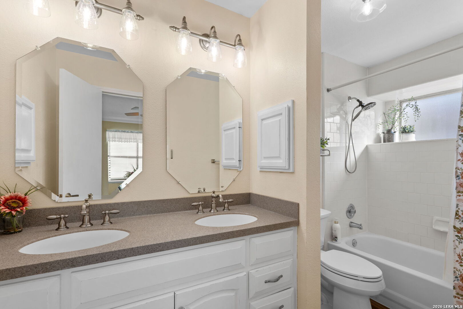 2501 Newning Schertz, TX 78154 - Photo 20 of 28 a bathroom with a granite countertop sink a toilet a large mirror a bathtub and shower