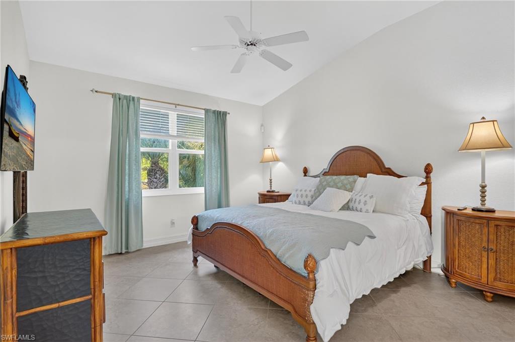 7092 Timberland Circle, Unit 201 Naples, FL 34109 - Photo 18 of 43 a bedroom with a bed and a chandelier