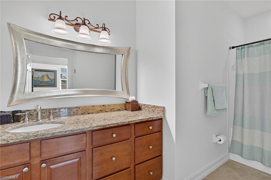7092 Timberland Circle, Unit 201 Naples, FL 34109 - Photo 25 of 43 a bathroom with a granite countertop sink vanity and mirror