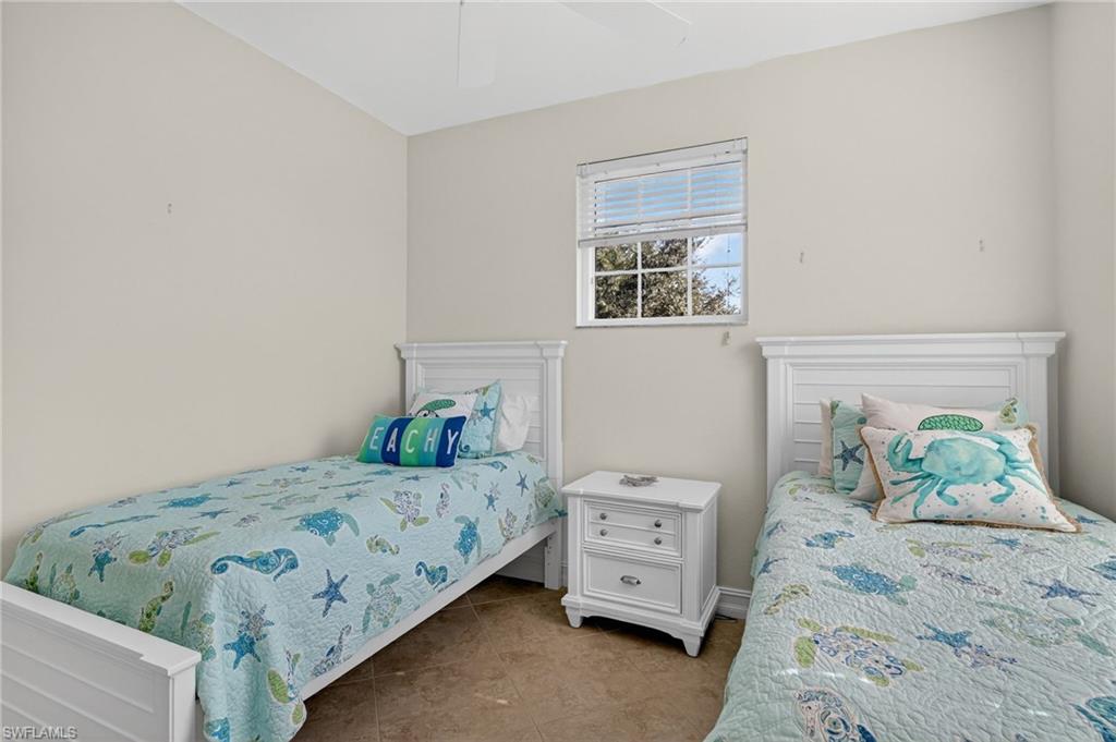 7092 Timberland Circle, Unit 201 Naples, FL 34109 - Photo 28 of 43 a bedroom with a bed and wooden floor
