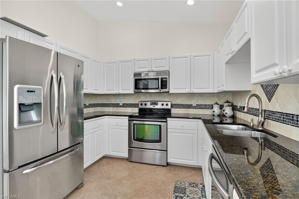 7092 Timberland Circle, Unit 201 Naples, FL 34109 - Photo 7 of 43 a kitchen with granite countertop a refrigerator stove and sink