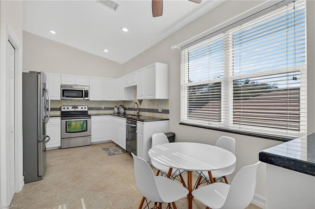 7092 Timberland Circle, Unit 201 Naples, FL 34109 - Photo 9 of 43 a kitchen with white cabinets and white appliances