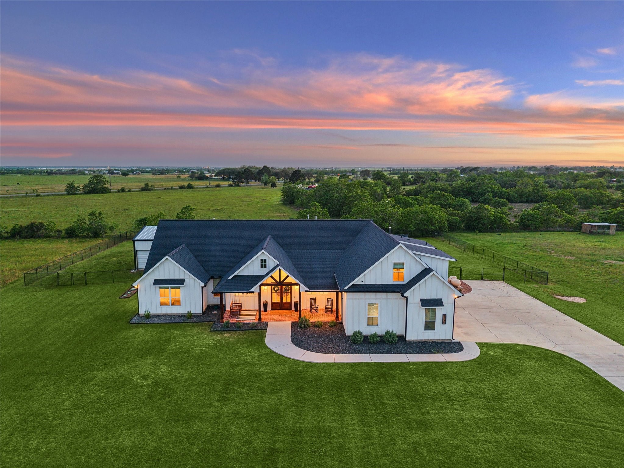 5131 Timber Ridge Drive Sealy, TX 77474 - Photo 47 of 50 This charming home features a modern farmhouse design with a spacious front yard, expansive driveway, and a beautiful porch. Surrounded by vast green fields, it offers serene countryside views. Perfect for those seeking tranquility and space.