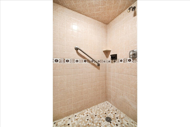 2252 West 800 North Clinton, UT 84015 - Photo 25 of 38 Tiled shower stall featuring mosaic floor tiling, neutral wall tiling, an accent tile band, and a chrome grab bar
