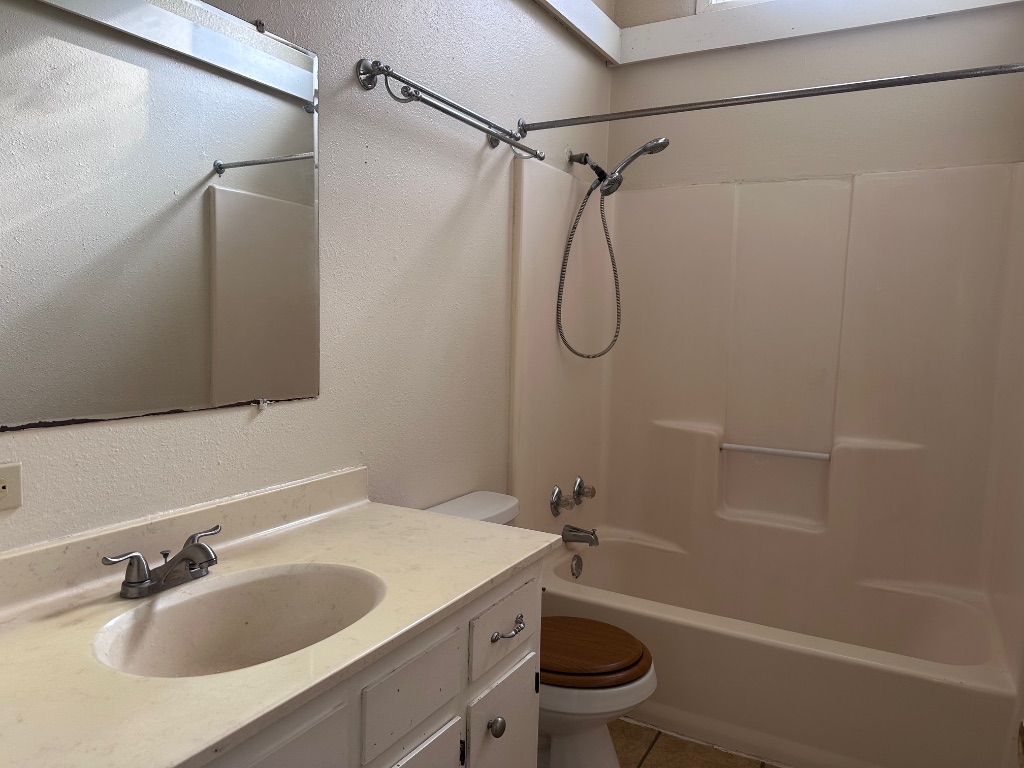 114 Thorne Road, Unit B Cedar Creek, TX 78612 - Photo 9 of 11 a bathroom with a granite countertop sink toilet and shower