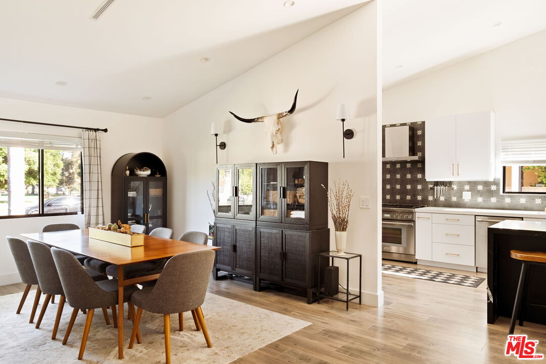 6151 Atoll Avenue Valley Glen, CA 91401 - Photo 11 of 58 a dining room with furniture a kitchen and a chandelier