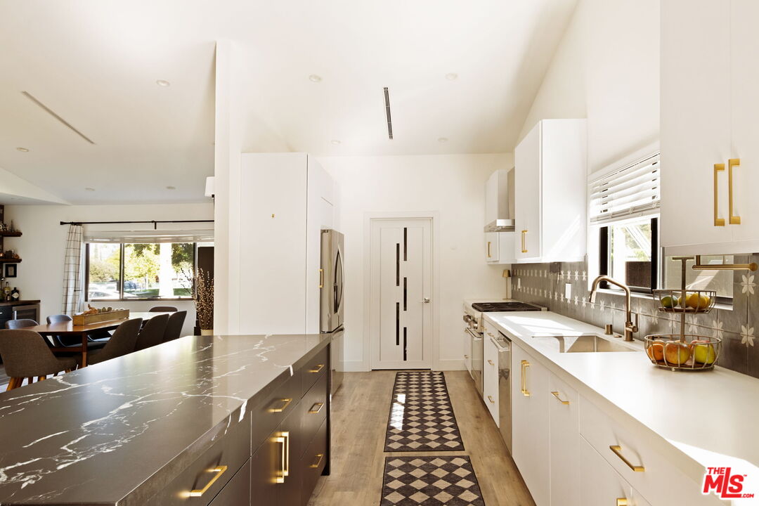 6151 Atoll Avenue Valley Glen, CA 91401 - Photo 19 of 58 a kitchen with stainless steel appliances a sink stove and cabinets