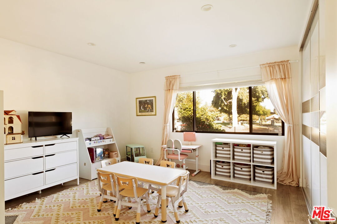 6151 Atoll Avenue Valley Glen, CA 91401 - Photo 32 of 58 a room with furniture a flat screen tv and a floor to ceiling window