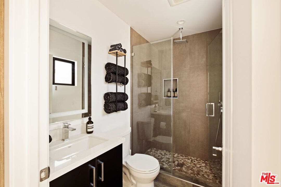 6151 Atoll Avenue Valley Glen, CA 91401 - Photo 36 of 58 a bathroom with a sink toilet a shower and a mirror