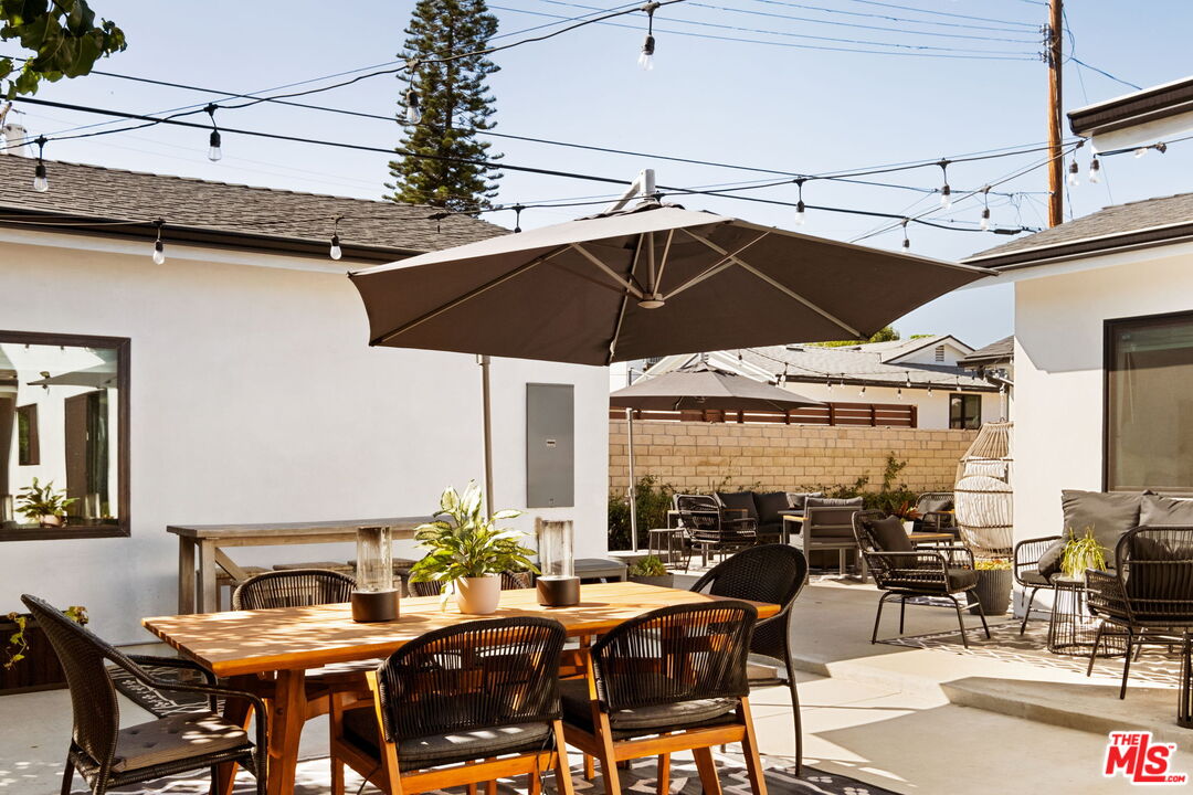 6151 Atoll Avenue Valley Glen, CA 91401 - Photo 40 of 58 a view of a patio with table and chairs under an umbrella
