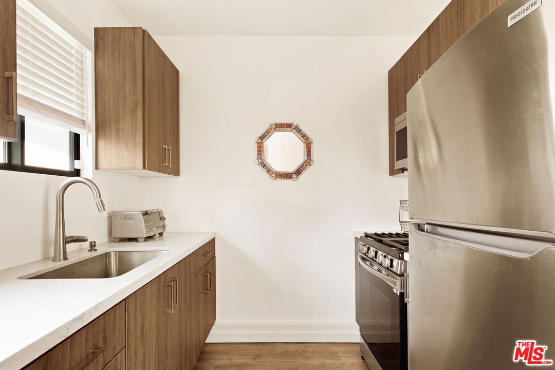6151 Atoll Avenue Valley Glen, CA 91401 - Photo 44 of 58 a kitchen with stainless steel appliances granite countertop a sink and a refrigerator