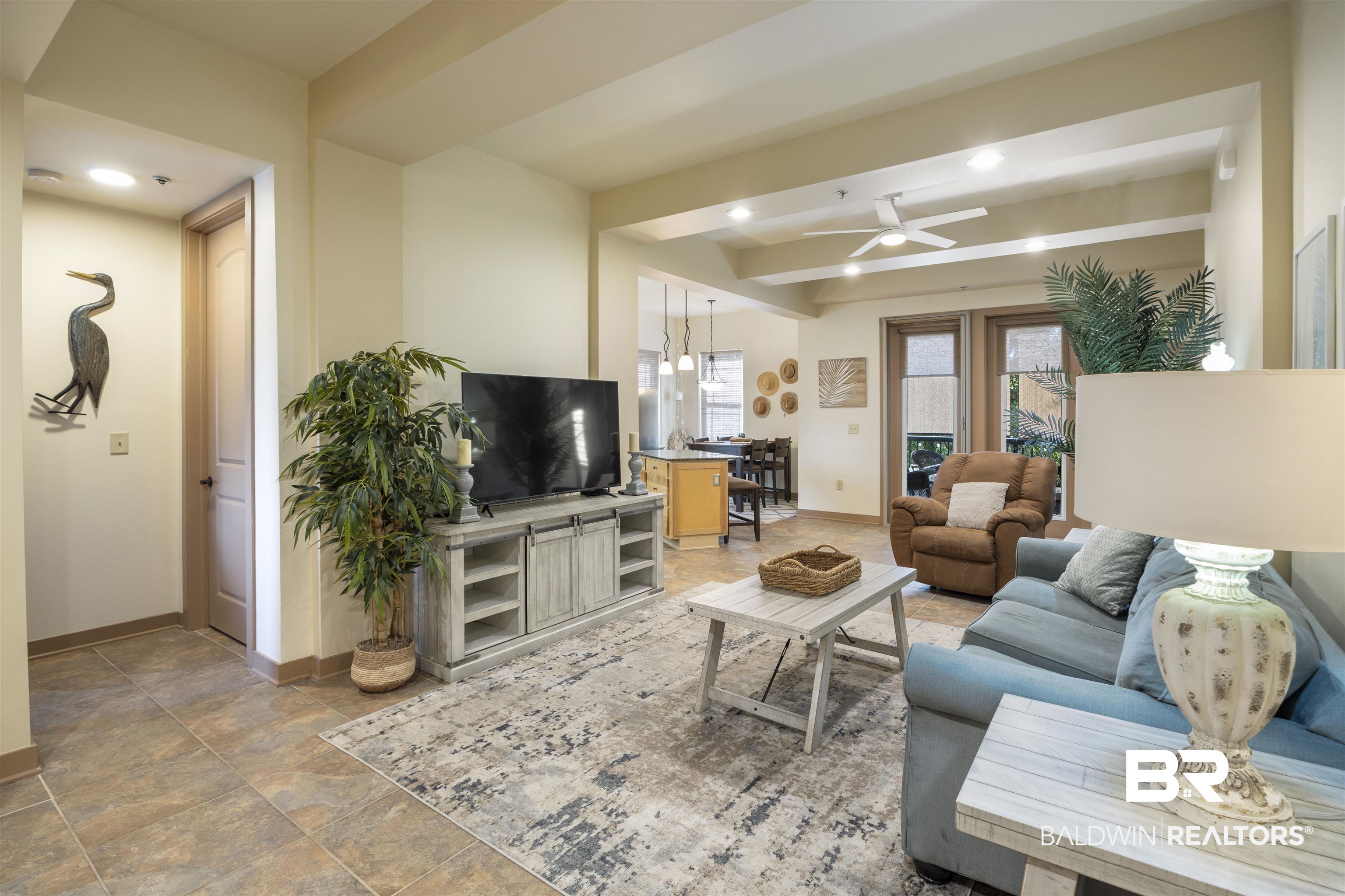 1430 Regency Road, Unit B201 Gulf Shores, AL 36542 - Photo 13 of 59 Living area featuring a ceiling fan, stone finish floors, beamed ceiling, and recessed lighting