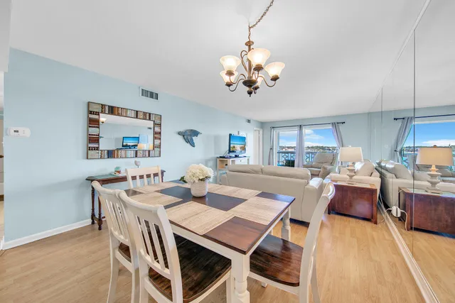 a view of a dining room with furniture a rug and wooden floor