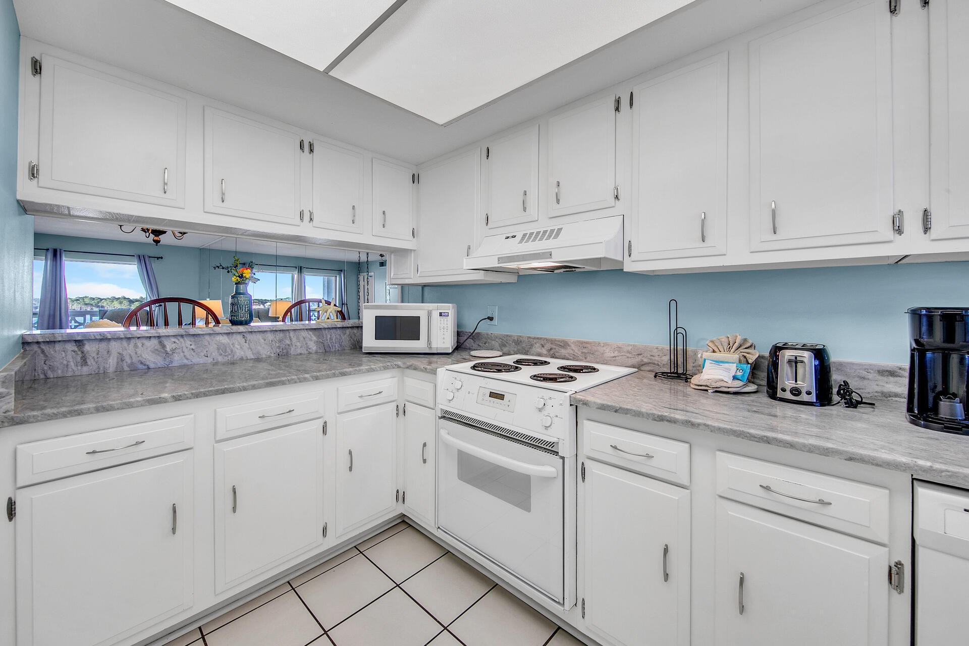 909 Santa Rosa Boulevard, Unit 561 Fort Walton Beach, FL 32548 - Photo 6 of 61 a kitchen with granite countertop white cabinets and white appliances