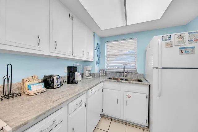 a kitchen with granite countertop cabinets a sink a window and stainless steel appliances