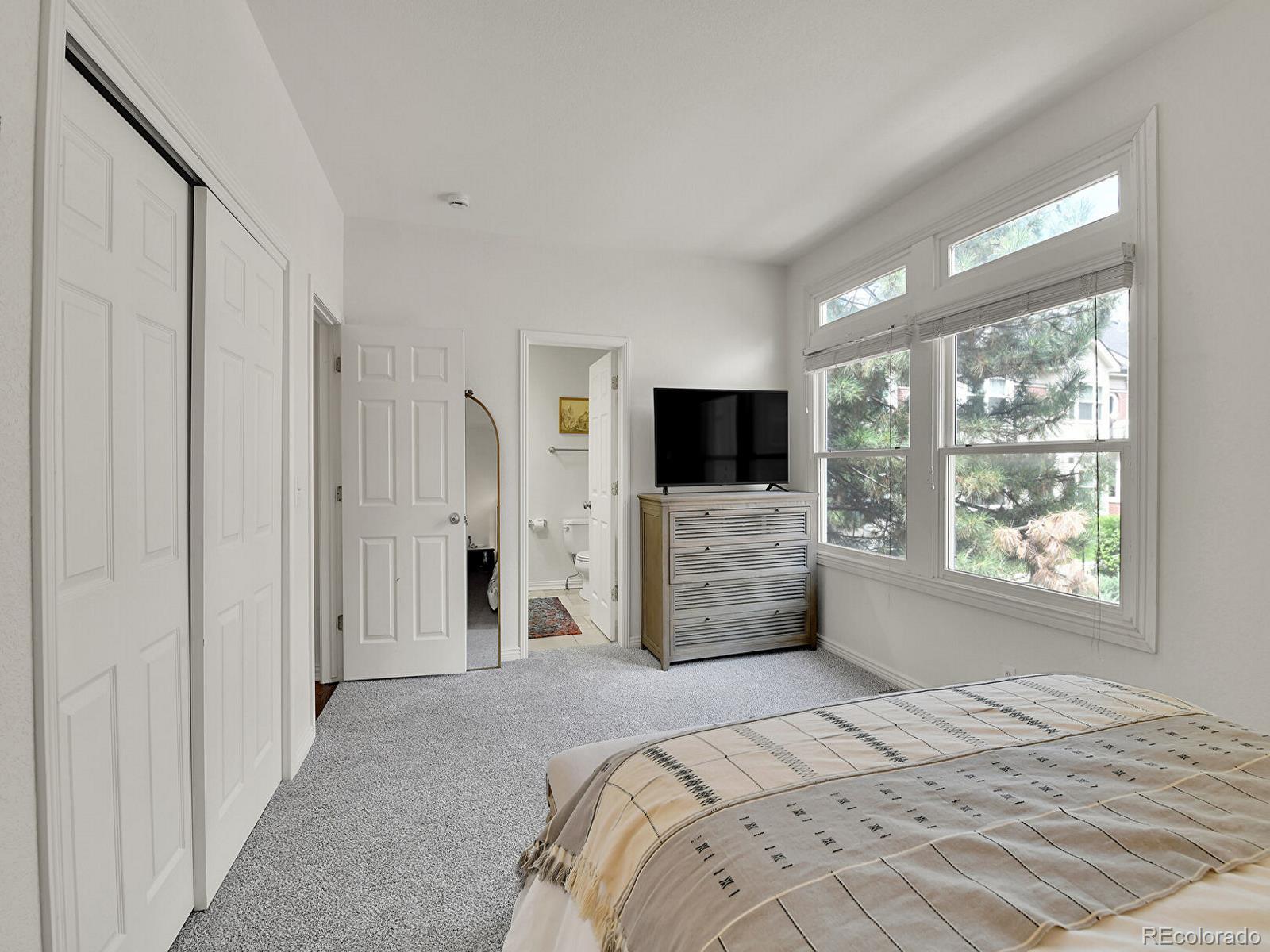 45 Jackson Street, Unit D Denver, CO 80206 - Photo 15 of 29 a bedroom with a bed and a flat screen tv