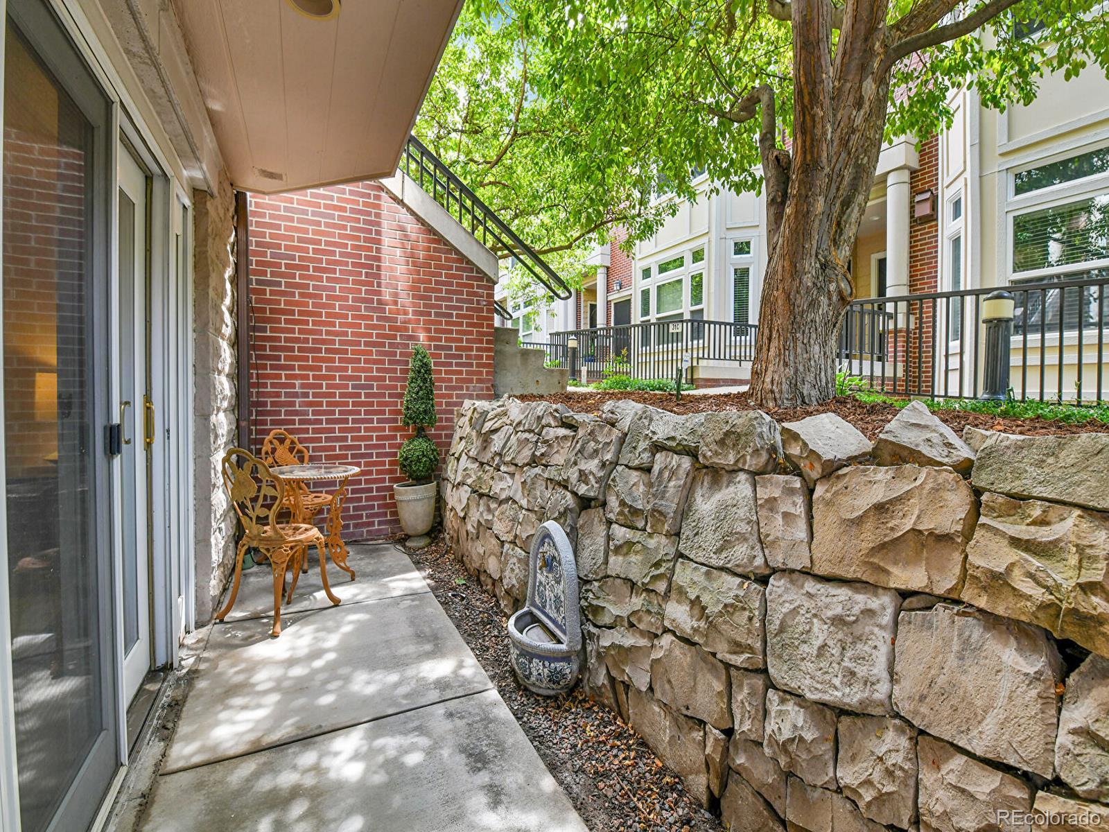 45 Jackson Street, Unit D Denver, CO 80206 - Photo 22 of 29 a view of a backyard with table and chairs and wooden fence