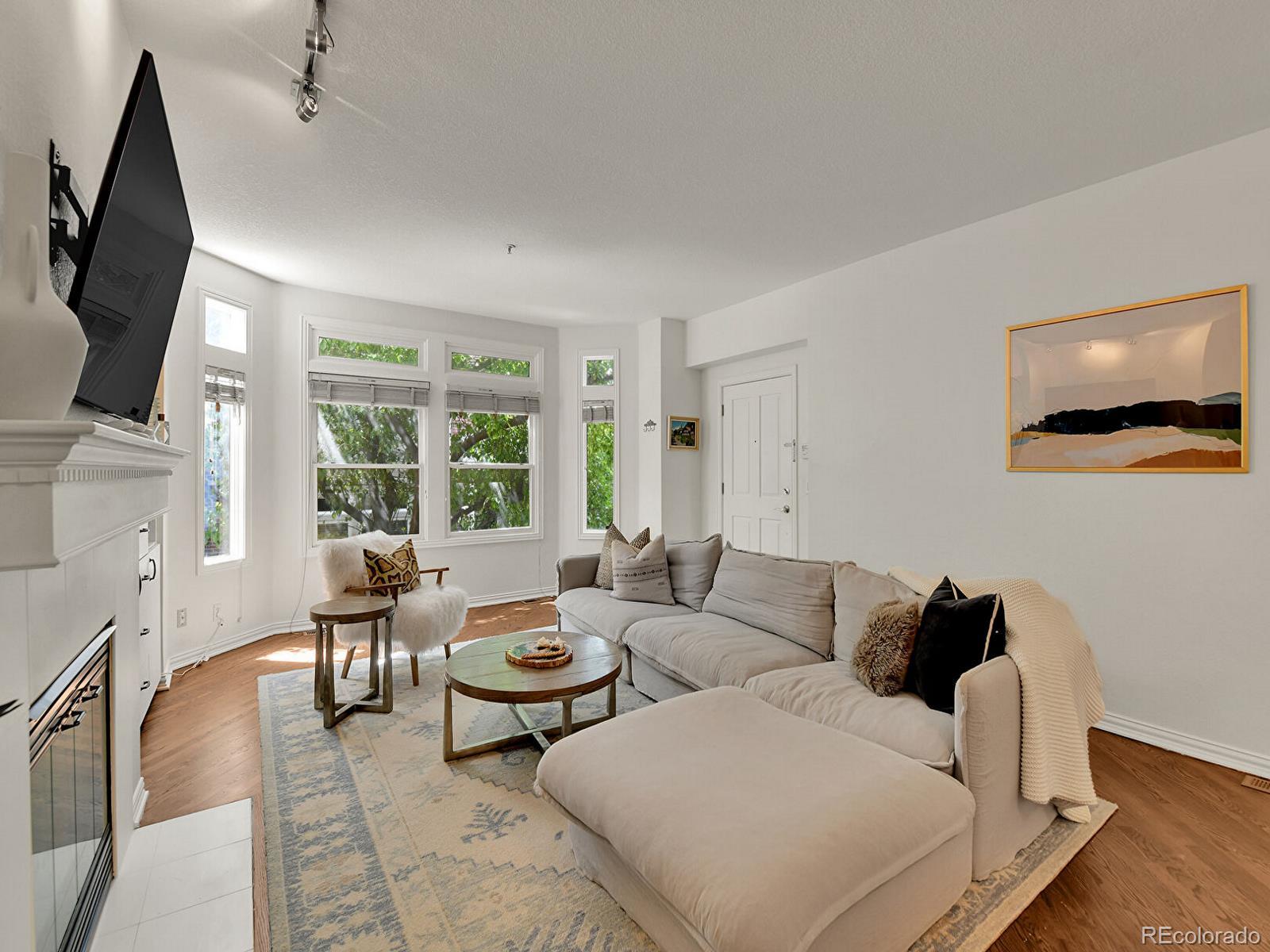 45 Jackson Street, Unit D Denver, CO 80206 - Photo 3 of 29 a living room with furniture and a flat screen tv