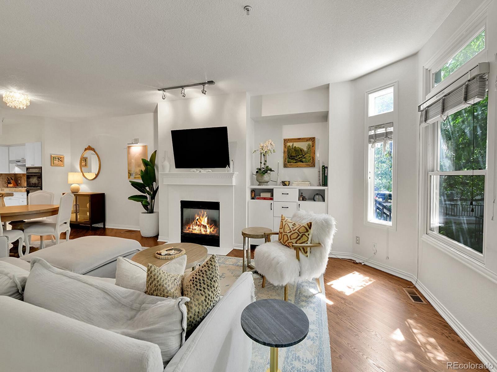 45 Jackson Street, Unit D Denver, CO 80206 - Photo 5 of 29 a living room with furniture a fireplace and a flat screen tv