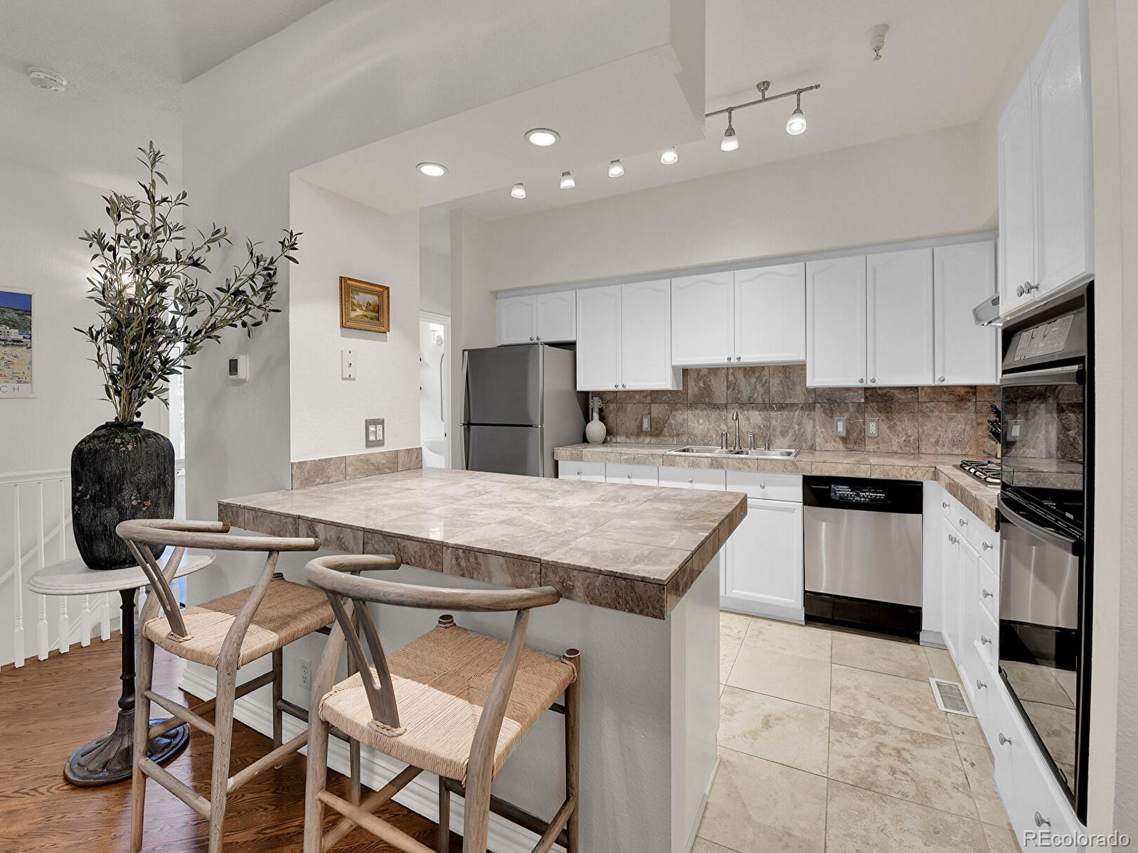 45 Jackson Street, Unit D Denver, CO 80206 - Photo 8 of 29 a kitchen with kitchen island granite countertop a stove a sink cabinets and a refrigerator