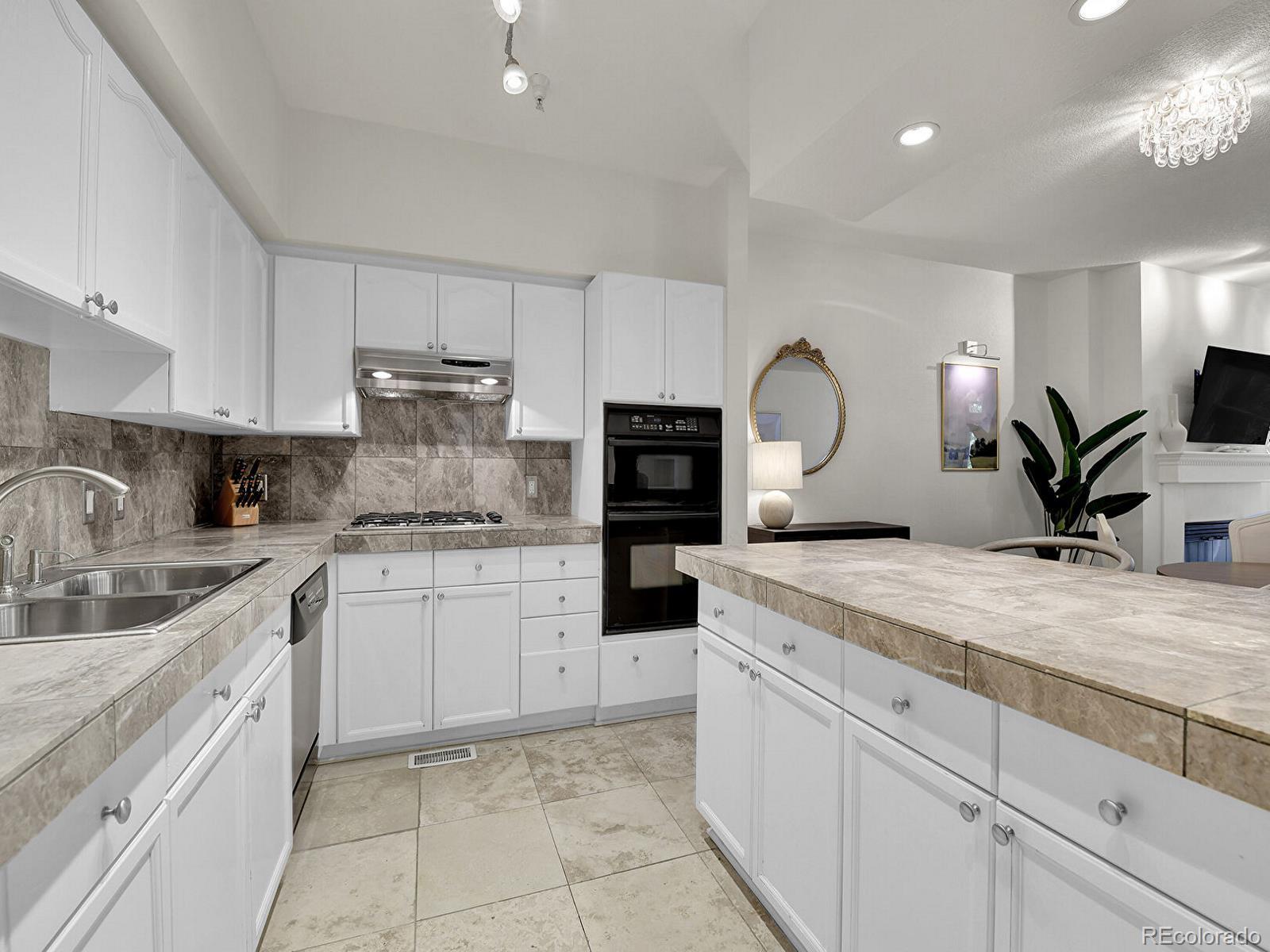 45 Jackson Street, Unit D Denver, CO 80206 - Photo 9 of 29 a kitchen with granite countertop a sink and white cabinets