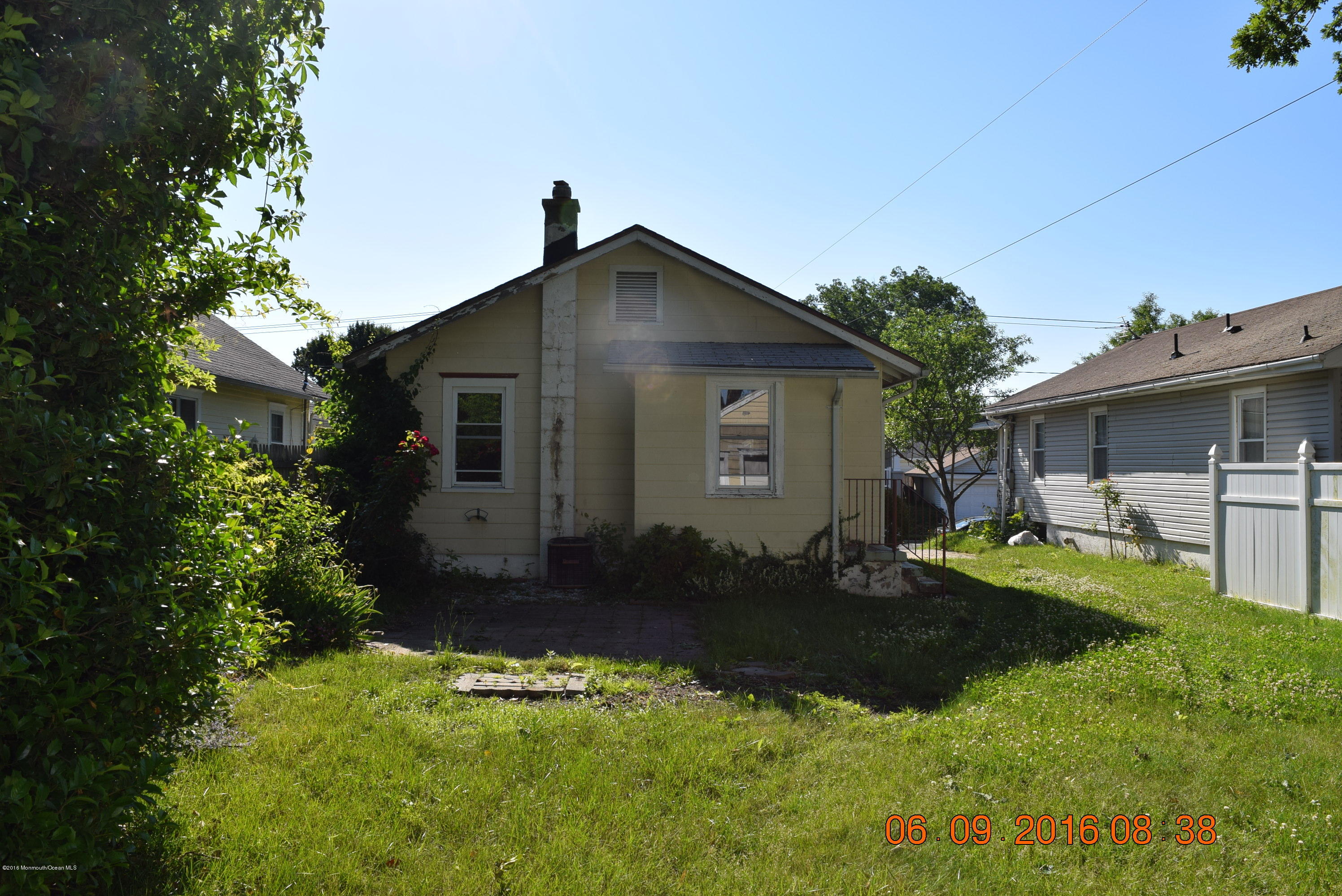 807 Ridge Avenue Neptune City, NJ 07753 - Photo 5 of 15 a backyard of a house with table and chairs under an umbrella