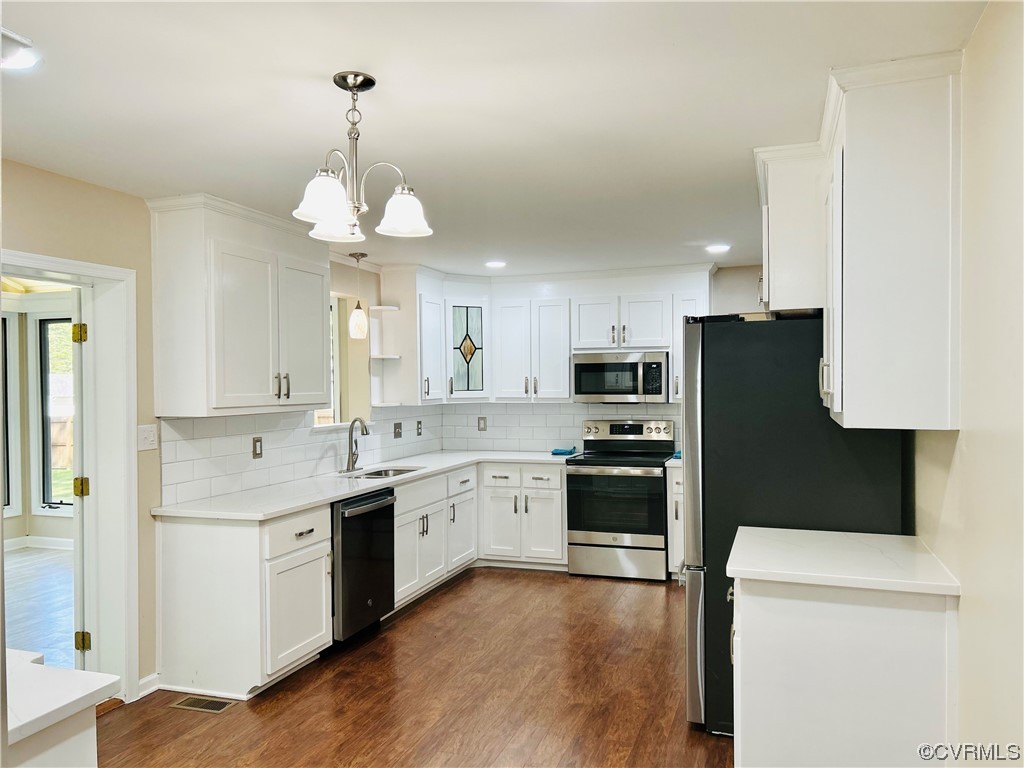 4416 Treely Road Chester, VA 23831 - Photo 6 of 22 a kitchen with stainless steel appliances granite countertop a refrigerator a sink dishwasher a stove and white countertops with wooden floor