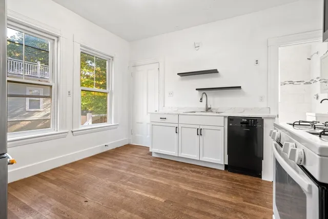 a kitchen with a stove a sink and a window