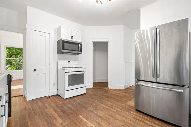 a kitchen with granite countertop a refrigerator and a stove top oven