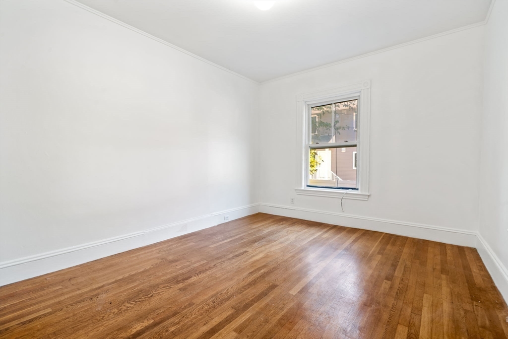 168 Elliot Street, Unit 1 Newton, MA 02464 - Photo 6 of 14 an empty room with wooden floor and windows