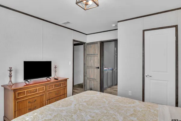a bedroom with a bed and a flat screen tv