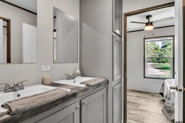 a bathroom with a granite countertop sink a mirror and a shower