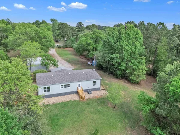 an aerial view of a house with a yard and lake view